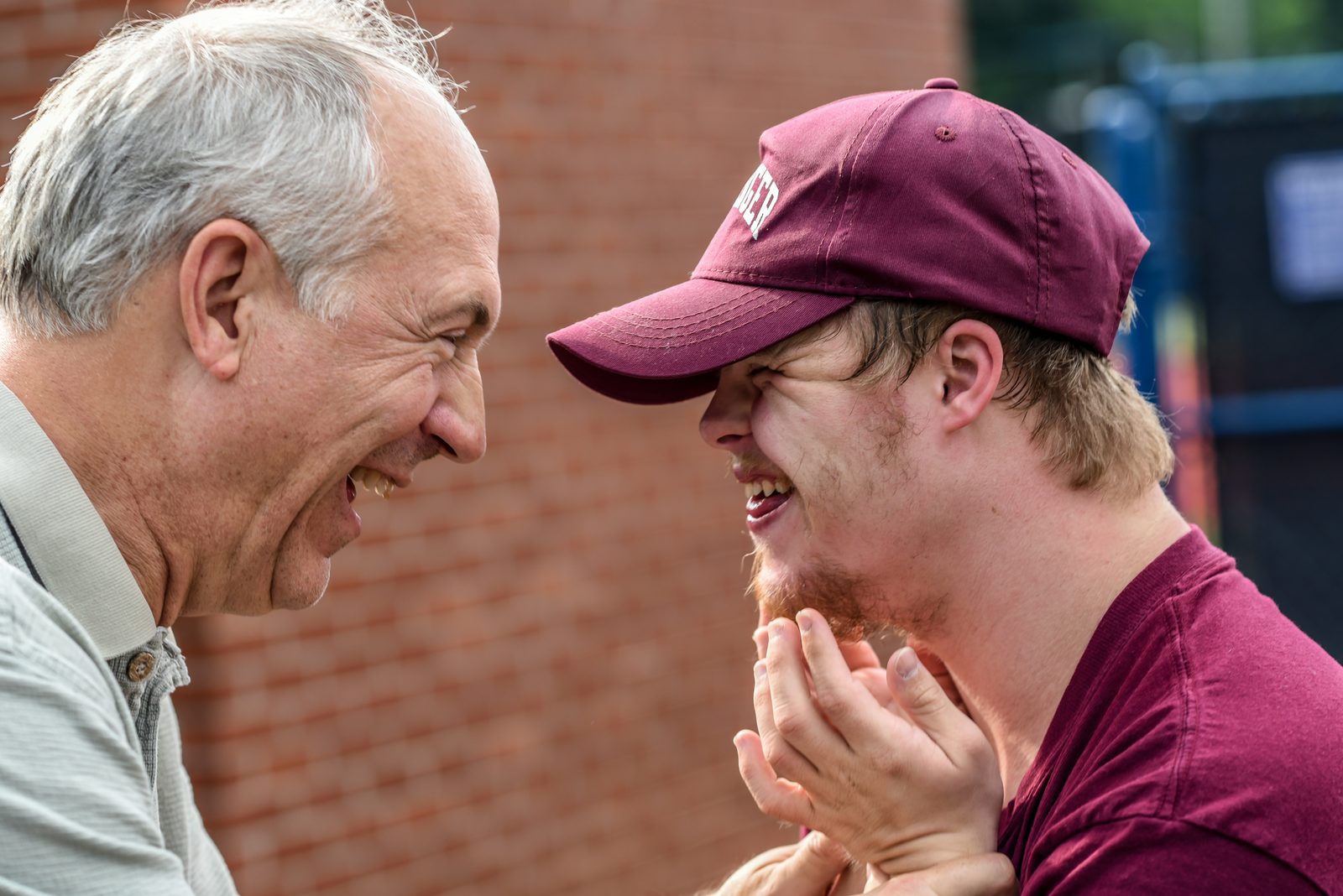 A participant and a support worker laughing together